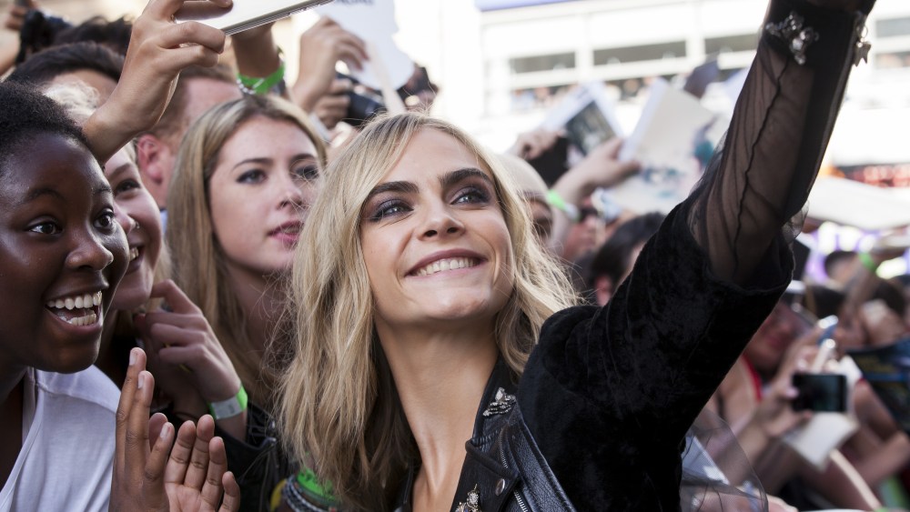 Cara Delevingne takes a selfie with her fans at the "Suicide Squad" film premiere in London.