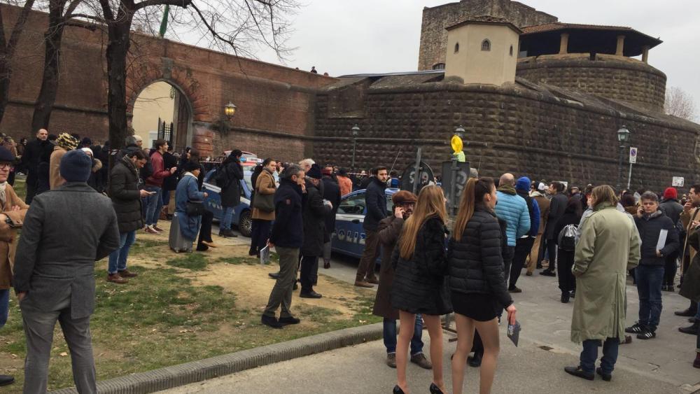 Models and spectators stand outside the Fortezza da Basso after a bomb scare.