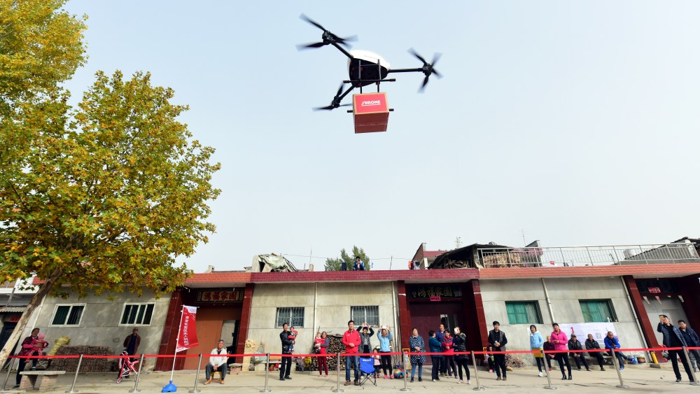 XI'AN, CHINA - NOVEMBER 10:  An unmanned delivery helicopter of JD.com delivers express parcels to villagers on November 10, 2016 in Xi'An, Shaanxi Province of China. It takes the unmanned delivery helicopter about 5 minutes to arrive at the destination, which is 2.3 kilometers away from its starting point. Express parcels are delivered to rural areas around cities in Xi'An by unmanned delivery helicopters, and in this way to improve efficiency and reduce cost.  (Photo by VCG/VCG via Getty Images)
