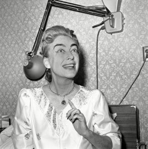 Joan Crawford Actress Joan Crawford, recuperating in the hospital because of her bout with pneumonia, points to a $100,000 sapphire necklace which she's wearing with her hospital gown by Dior in Hollywood, . Work on the movie set of "Hush, Hush, Sweet Charlotte," in which Joan teams with Bette Davis, ground to a halt because of Miss Crawford's illness. This is the first time in my long career that I have ever held up a picture," she told her interviewerJoan Crawford, Los Angeles, USA