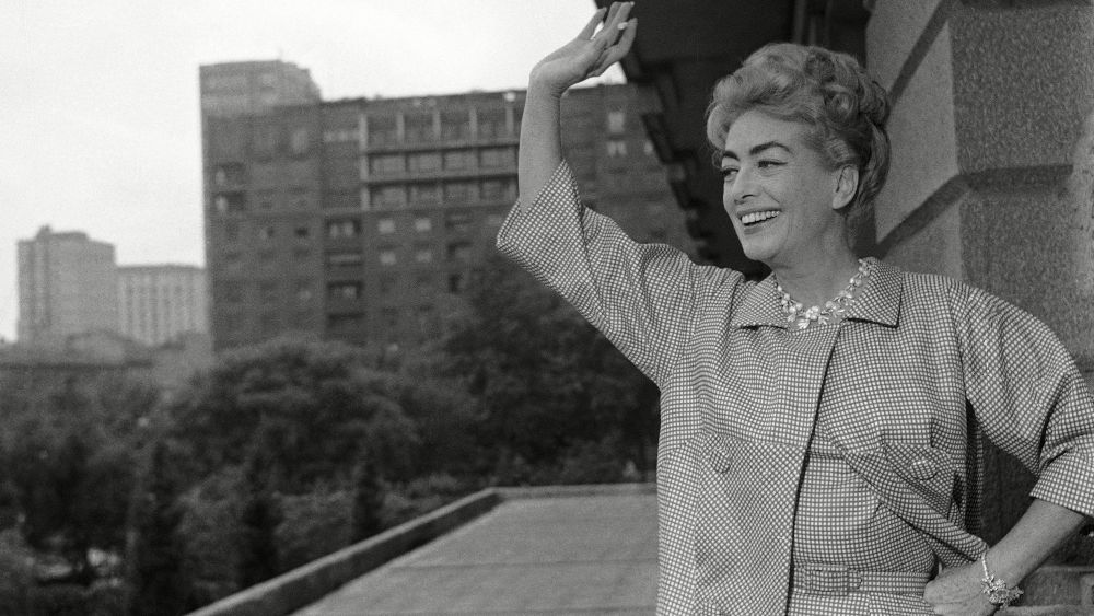 Joan Crawford Joan Crawford, one of the most outstanding American movie actresses until two years ago has turned into a successful businesswoman. It is because of this second activity of hers that Joan has paid a visit to Milan, Italian industrial and business center. She came to Italy accompanied by a group of managers of a big American company of which she a shareholder, for the promotion of sale of the company's product. Joan Crawford is waving on the terrace of her hotel apartment in MilanJoan Crawford, Milan, Italy