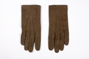 Material: Vellaskin Measurement: 9 1/2 x 4 inchesDescription: Handsewn brown gloves with black stitching and single button at wrist. These gloves were worn by John F. Kennedy to his Inaugural ceremony in January of 1961.