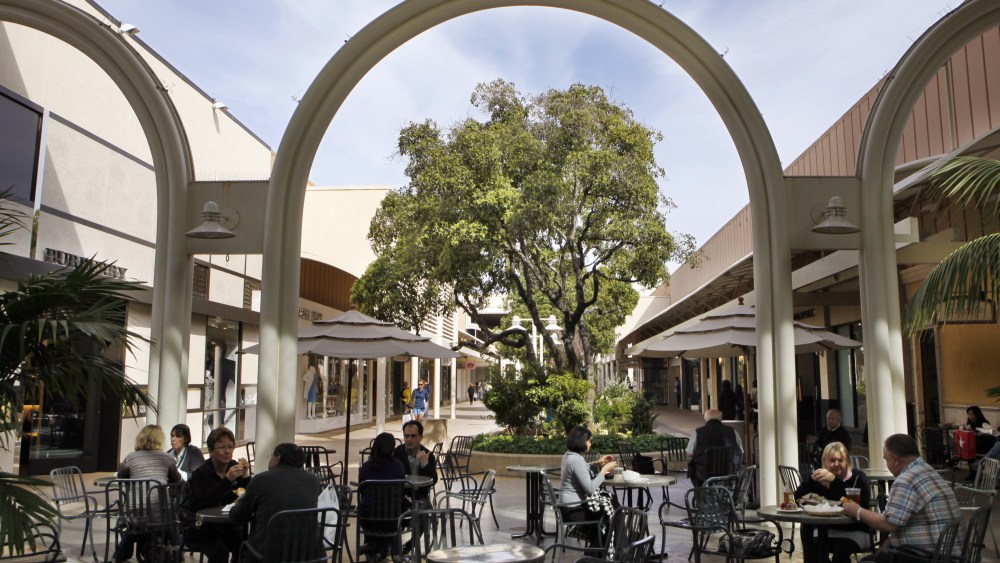 People sit at tables at the Stanford Shopping Center, a Simon Property Group property in Palo Alto, Calif., . Simon Property Group, the nation's largest shopping mall owner, made a $10 billion hostile bid Tuesday to acquire ailing rival General Growth PropertiesSimon Properties General Growth, Palo Alto, USA