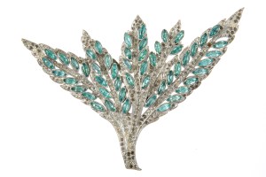 A simulated diamond and aquamarine costume ornament in foliate design.  Worn by Jean Harlow as a closure for an evening cape in "Libeled Lady" (MGM, 1936).