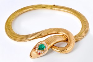 An 18K yellow snake chain necklace terminating in serpent head accented with simulated diamonds, rubies and emerald. Worn by Rita Hayworth in "Down to Earth" (Columbia Pictures, 1947).