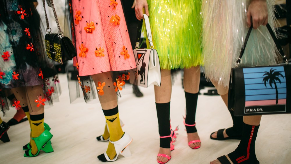Miuccia Prada’s collection gave several strong accessory proposals for fall. There were glowing fluorescent bags, white rubber boots, lady bags with cartoon robots, small sci-fi sunglasses and heels with bungee-cord details. The range might have been a wink to iconic pieces of past collections, but these were supercharged and about the now, as in the return of the flame shoe done in a neon pink flame sandal style this time. Another key piece, reworked from the Prada lexicon, was a variety of socks, some with the iconic Prada sport red label, others with a knit version of the triangle logo plaque. — Thomas Waller