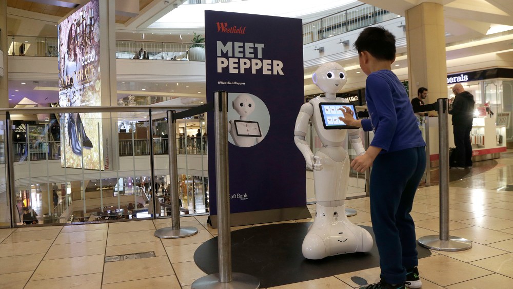 A boy plays with Pepper the robot at Westfield Mall in San Francisco. While merrily chirping, dancing and posing for selfies, Pepper looks like another expensive toy in the San Francisco mall where it will be entertaining shoppers through mid-February. But it would be a mistake to dismiss Pepper as mere child's play, even though kids flock around the 4-foot-tall humanoid as it speaks in a cherubic voice that could belong to either a boy or girlAmbitious Robot, San Francisco, USA - 22 Dec 2016