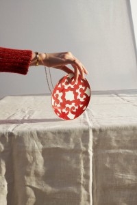 From left: Hermès of Paris’ sweater; Cartier’s Love Bracelet in 18-karat yellow gold; Foundrae’s pendant necklace, and Hermès’ porcelain break and butter plate.