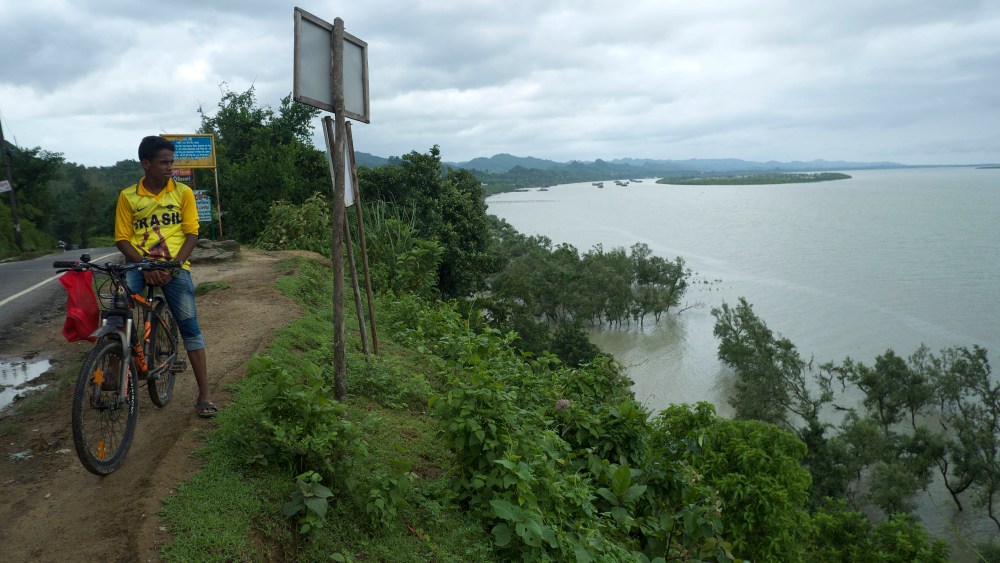 A man looks across the Naf river. More than 700,000 Rohingya refugees have crossed the Naf River from Myanmar into Bangladesh to flee persecution from the Myanmar military.