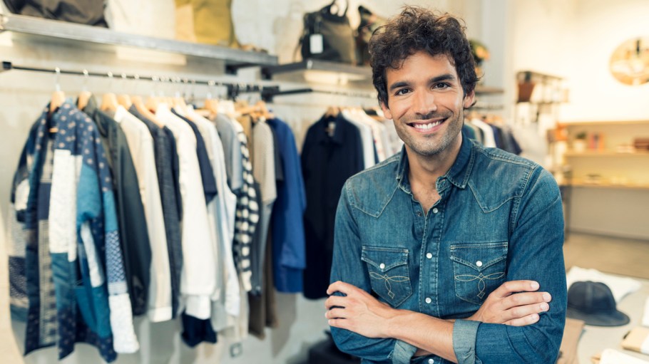 Portrait of cheerful owner in clothing store. Looking at camera