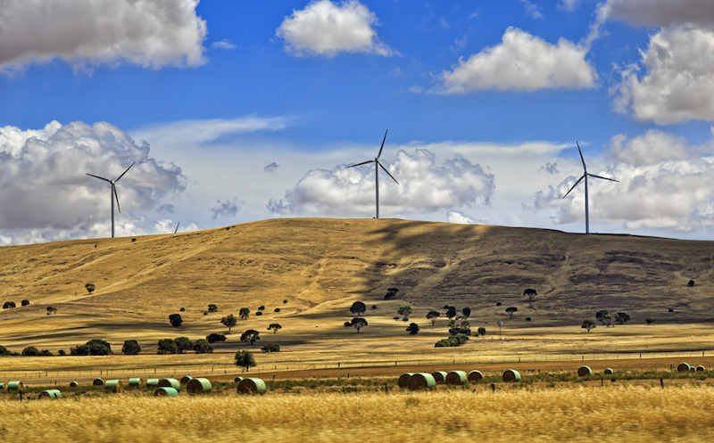 Rural region with cultivated farms and haystacks providing grounds for renewable energy