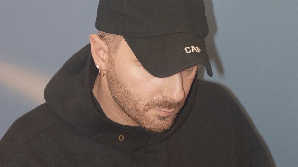 Designer Demna Gvasalia in his signature black baseball cap and oversized hoodie.