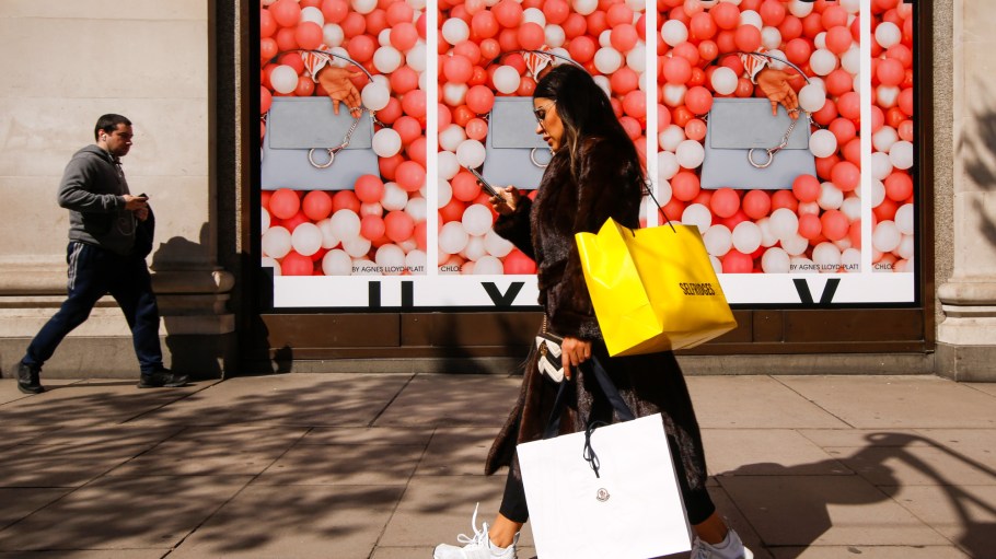 A shopper carries bags past Selfridges & Co. Ltd. department store in Oxford Street in central London, U.K., on Tuesday, April 17, 2018
