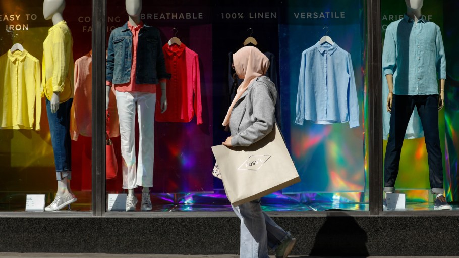 A woman wearing a headscarf carries a shopping bag past a Marks & Spencer Group Plc store on Oxford Street in central London, U.K., on Tuesday, April 17, 2018.