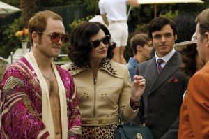 Taron Egerton plays Elton John, Richard Madden plays John Reid and Bryce Dallas Howard plays Sheila in Rocketman from Paramount Pictures.