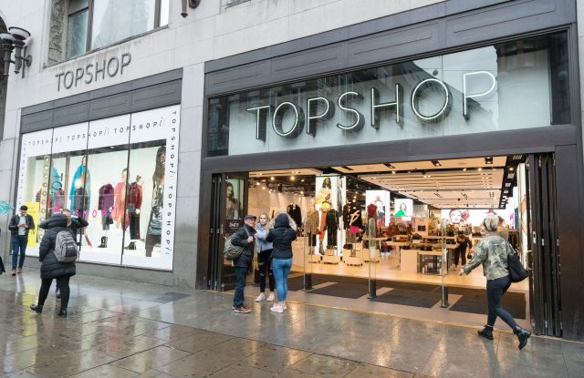 A woman holding an umbrella walks past the Topshop flagshop store in Oxford Circus as it opens for customers.Top Shop business continues after Sir Phillip Green Allegations, London, UK - 26 Oct 2018