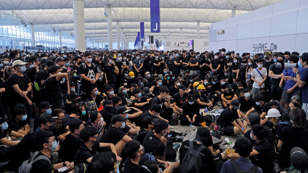 Protesters gather near an information board during a protest at the Hong Kong International Airport, . One of the world's busiest airports canceled all flights after thousands of Hong Kong pro-democracy protesters crowded into the main terminal Monday afternoonProtest, Hong Kong, Hong Kong - 12 Aug 2019