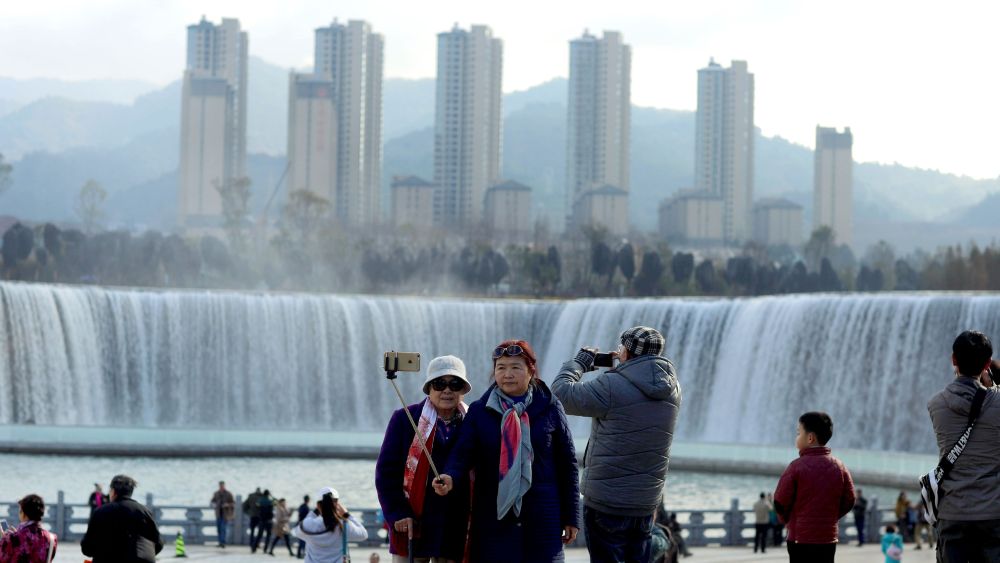 Visitors in front of Asia's largest man-made waterfall in Kunming, China.