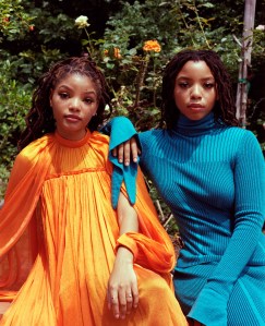 Halle in Carolina Herrera's cape mini dress. Chloe in Carolina Herrera's plaited rib tie turtleneck and flare skirt.