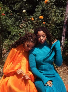 Halle in Carolina Herrera's cape mini dress. Chloe in Carolina Herrera's plaited rib tie turtleneck and flare skirt.