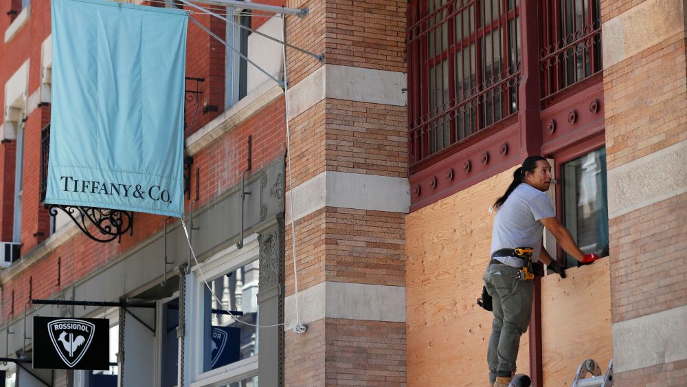 Worker installs boards over tiffany windows soho