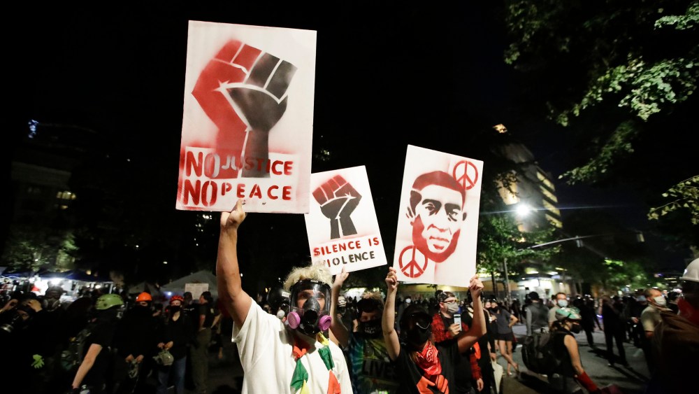 Demonstrators hold signs during a Black Lives Matter protest at the Mark O. Hatfield United States Courthouse in Portland.