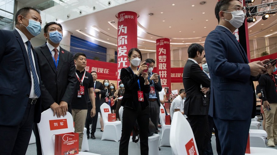 Attendees wear masks to curb the spread of the new coronavirus before the ceremony to mark the listing of JD.com on the Hong Kong Stock Exchange at the JD.com headquarters in Beijing on Thursday, June 18, 2020.