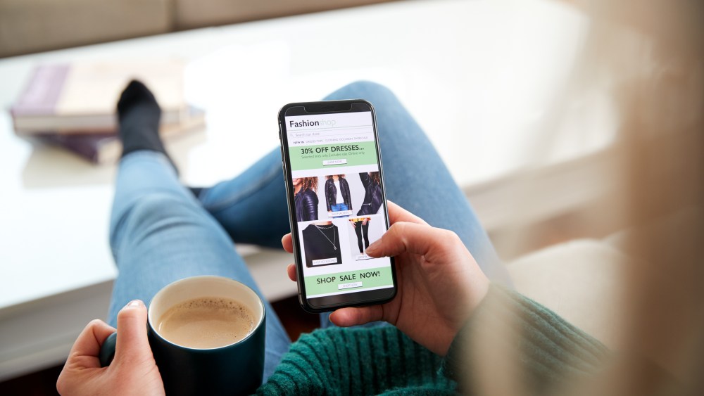 Close Up Of Woman Shopping For Clothes Online Using Mobile Phone App