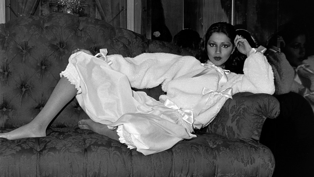 Model Kirat Bhinder poses in a fleece bed jacket with satin trim worn with over-the-knee pants designed by Lou Lou de la Falaise for Yves Saint Laurent's couture lingerie collection.