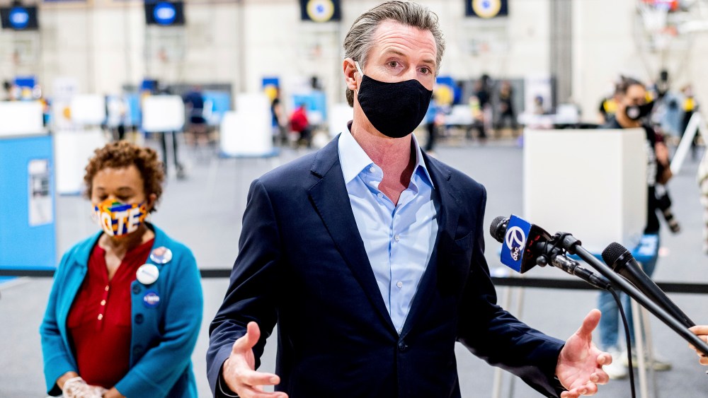 Gov. Gavin Newsom discusses the 2020 election while visiting the Golden State Warriors training facility, which is serving as a polling location, on Tuesday, Nov. 3, 2020, in Oakland, Calif. At left is Rep. Barbara Lee, D-Calif. (AP Photo/Noah Berger)