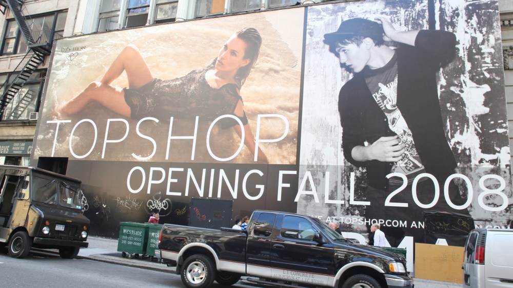 A sign advertising the opening of Topshop in NY.