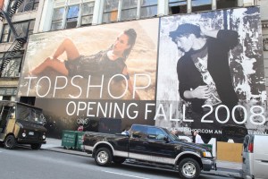 A sign advertising the opening of Topshop in NY.