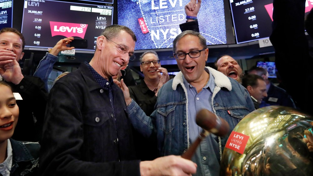 Levi Strauss CEO Chip Bergh, left, is joined by CFO Harmit Singh as he rings a ceremonial bell when his company's IPO begins trading on the floor of the New York Stock Exchange, Thursday, March 21, 2019. Levi Strauss & Co., which gave America its first pair of blue jeans, is going public for the second time. The 166-year-old company, which owns the Dockers and Denizen brands, previously went public in 1971, but the namesake founder's descendants took it private again in 1985. (AP Photo/Richard Drew)