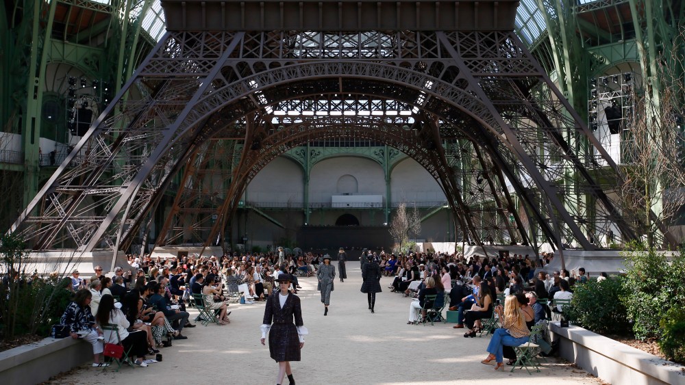A model wears a creation for Chanel's Haute Couture Fall/Winter 2017/2018 fashion collection presented under a replica of the Eiffel Tower at the Grand Palais in Paris Tuesday, July 4, 2017. (AP Photo/Francois Mori)