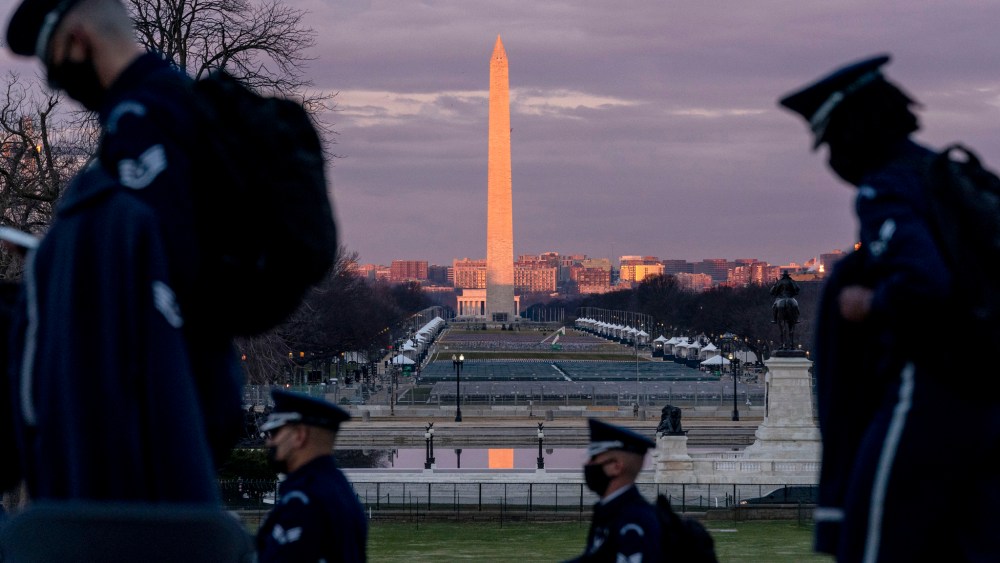 The Washington Monument and the National Mall are visible as members of the U.S. Air Force Honor Guard walk along the West Front of the U.S. Capitol.