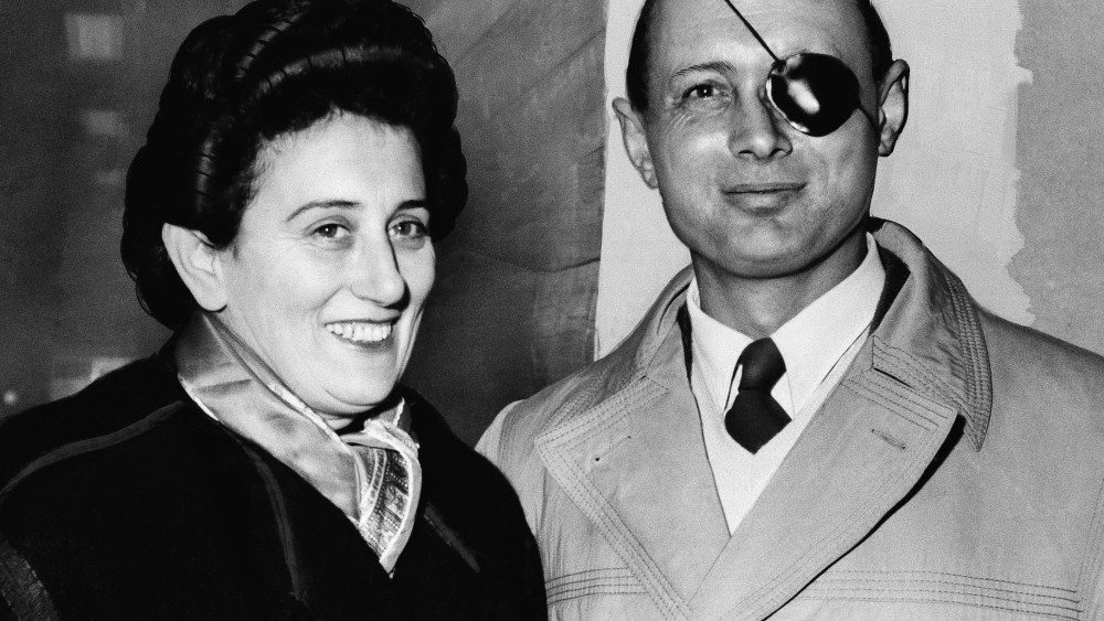 FILE - In this Jan. 13, 1958 file photo, Ruth Dayan stands with her husband, General Moshe Dayan, chief of staff of the Israeli Army, at London Airport.  Ruth Dayan, the Israeli fashion designer and peace activist has died at the age of 103, Israeli media reported Friday, Feb. 5, 2021. (AP Photo, File)