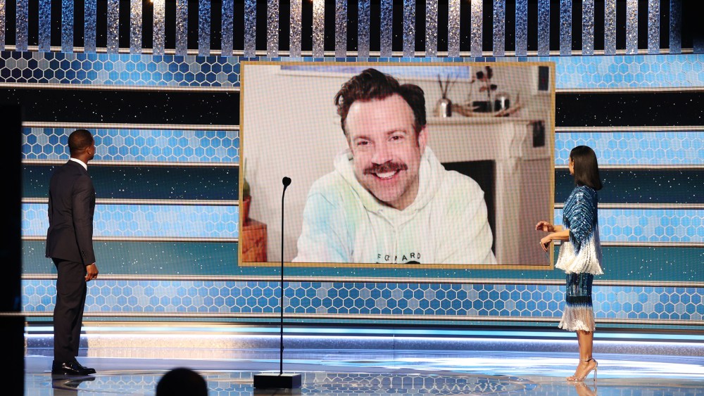 Jason Sudeikis in Listen + Lead Tie Dye Hoodie (c) accepts the Best Television Actor – Musical/Comedy Series award for ‘Ted Lasso’ via video from Sterling K. Brown (l) and Susan Kelechi Watson.