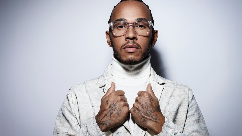 Lewis Hamilton wearing a frame from the Police x Lewis Hamilton capsule collection developed by De Rigo.