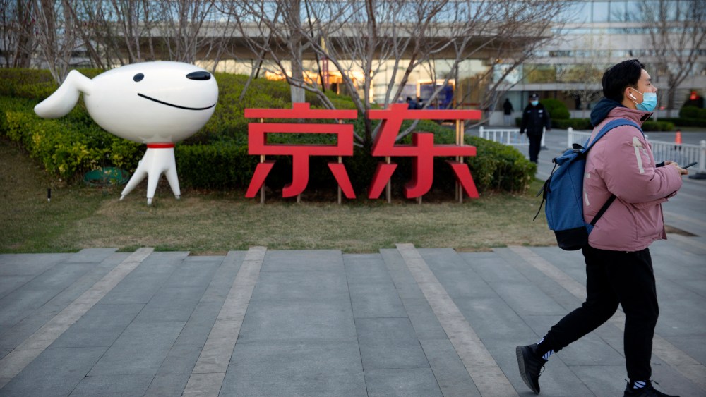 A man walks past the JD.com logo outside the company's headquarters in Beijing.