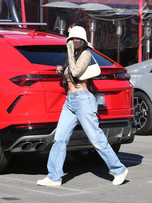 Kylie Jenner sports a crop-top and loose-fitting denim jeans.