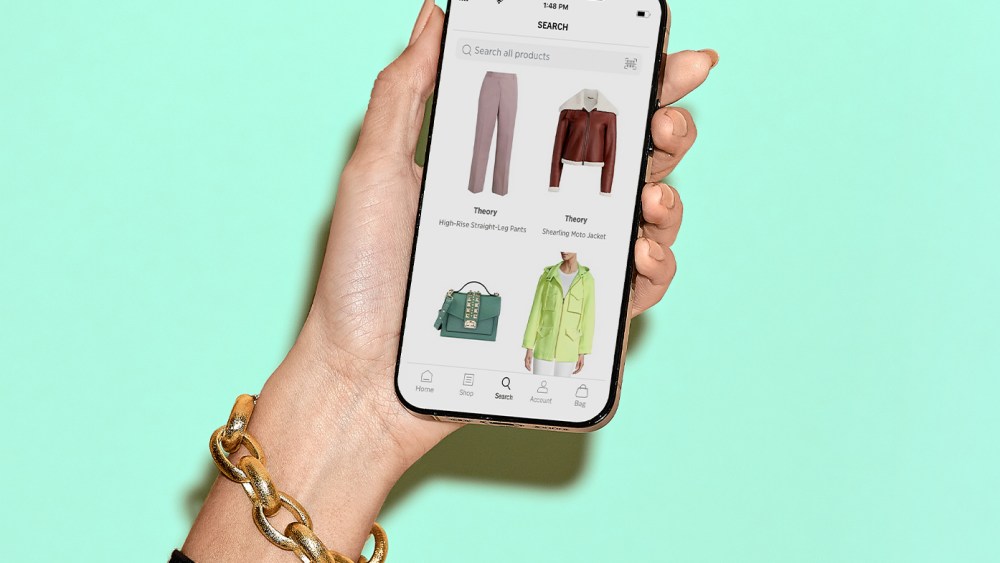 hand holding cell phone with the Saks Off 5th app