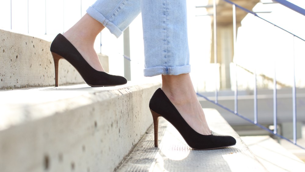 Profile of woman legs wearing high heels walking down stairs