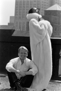 Designer Bob Mackie with a model wearing one of his designs for HB Furs Fall 1984 collection. Mackie designed this collection of coats for HB Furs as an homage to the work of fashion illustrator Erte.