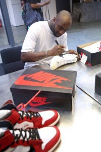 Virgil Abloh signing Nike trainers at the Off-White exhibition, 2017.
