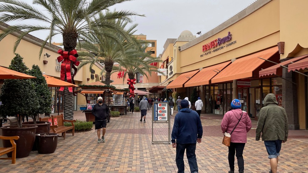 People shop the day before Christmas at the Citadel Outles amid the global coronavirus COVID-19 pandemic.