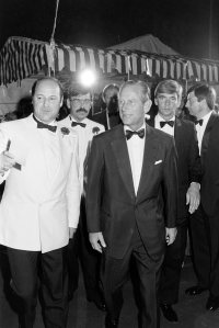 Prince Philip escorted by security at London's Berkeley Square Ball, 1985.