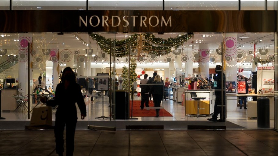 A security guard, right, stands at the entrance to a Nordstrom department store at the Grove mall in Los Angeles, Thursday, Dec. 2, 2021, where a recent smash-and-grab robbery took place.