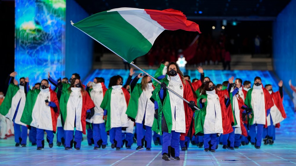 Michela Moioli, of Italy, carries her national flag into the stadium during the opening ceremony of the 2022 Winter Olympics