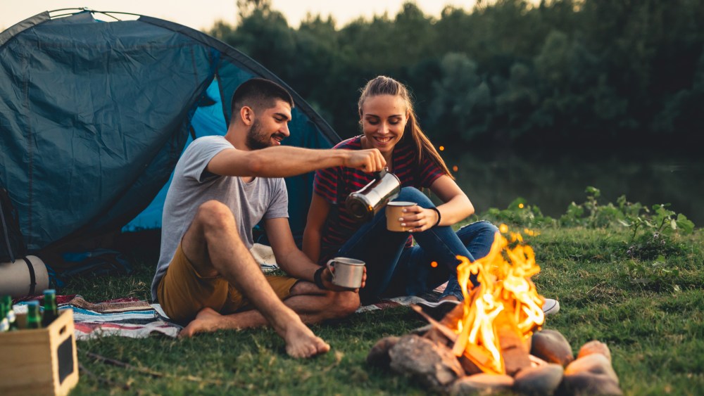 romantic couple on camping by the river outdoors