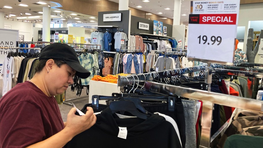 A customer checks price tags while shopping at a retail store in Schaumburg, Ill., Thursday, June 30, 2022.